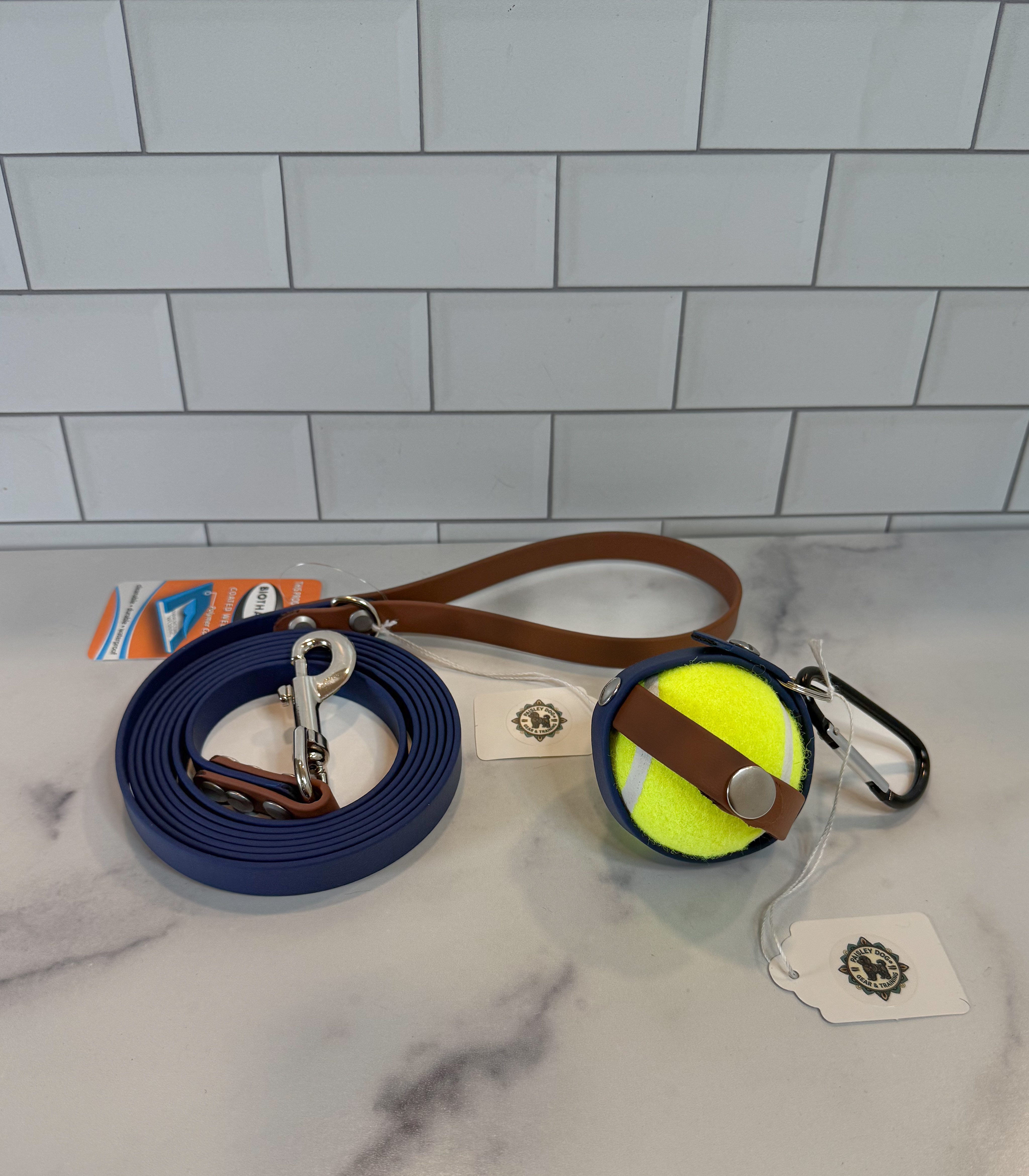 Item: Ball holder + leash set | Width: 5/8 in | Colors: Deep Sea & Brown 522 with matching ball holder | Hardware: silver